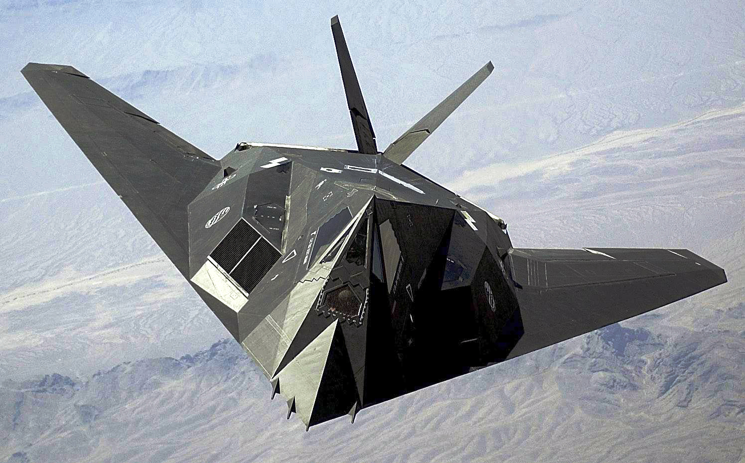 The F-117 flies in the sky.